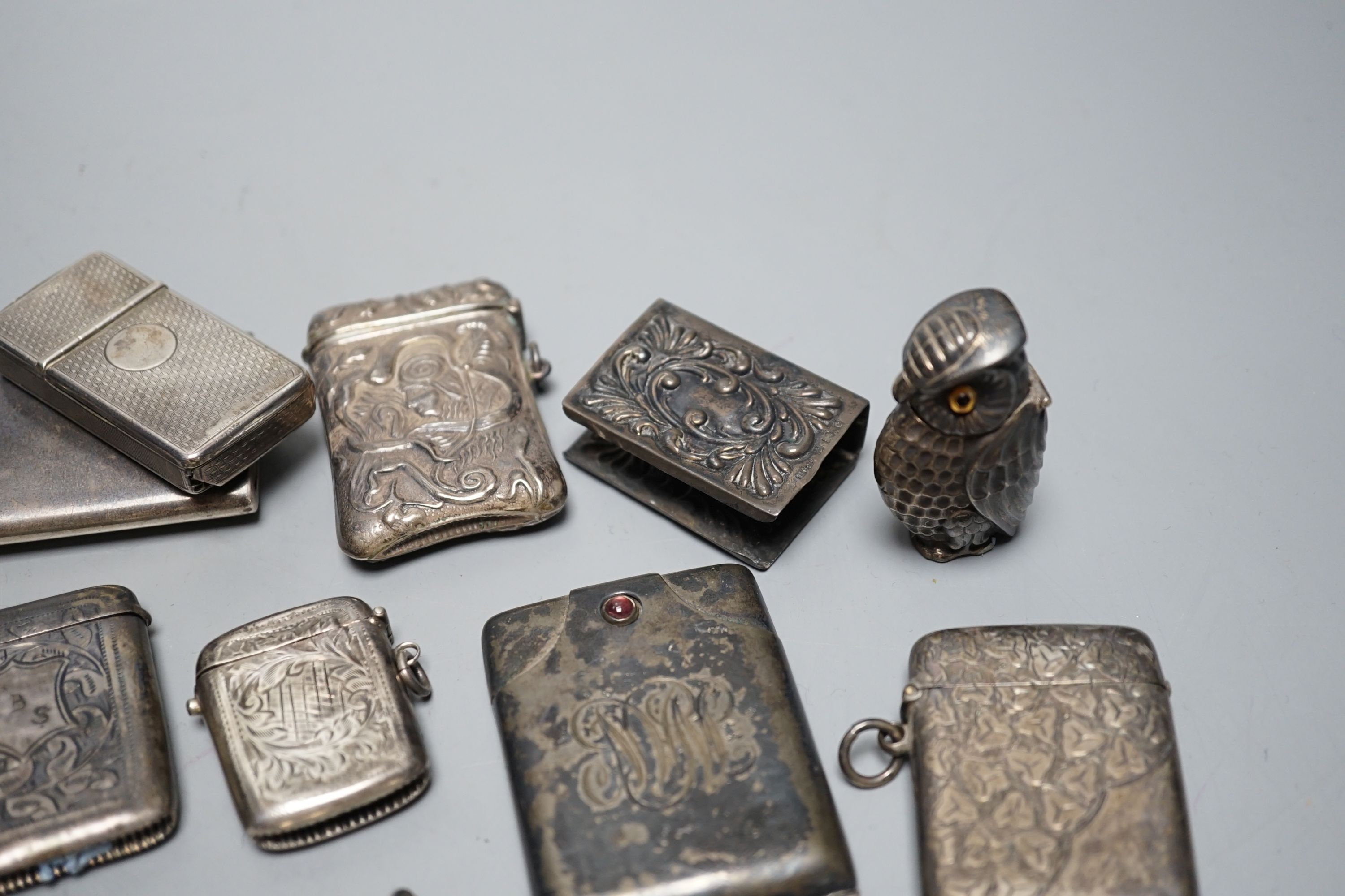 A collection of twenty six assorted mainly early 20th century silver or white metal vesta cases, including heart shape and combination vesta and cheroot cutter, largest 61mm and and seven assorted match cases or sleeves.